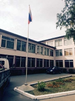 Флаг России на флагштоке перед зданием школы