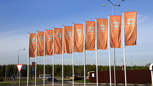Флаги на мачтах-флагштоках перед торговым центром