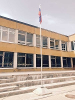 Флаг России на флагштоке перед зданием школы